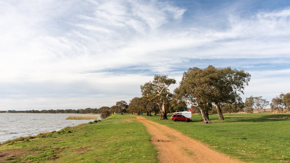 Grassy open campground beside a lake