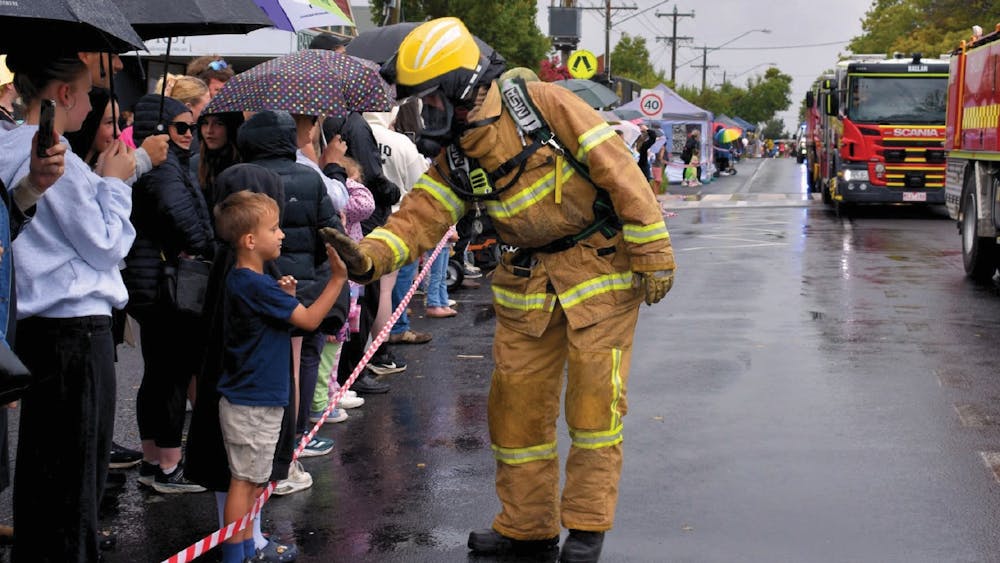 young person gives a fireman a High-Five