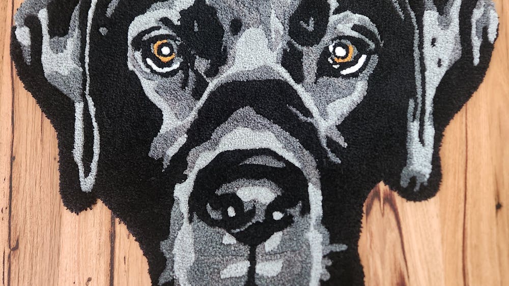 A black labradors head created from tufting into a rug.