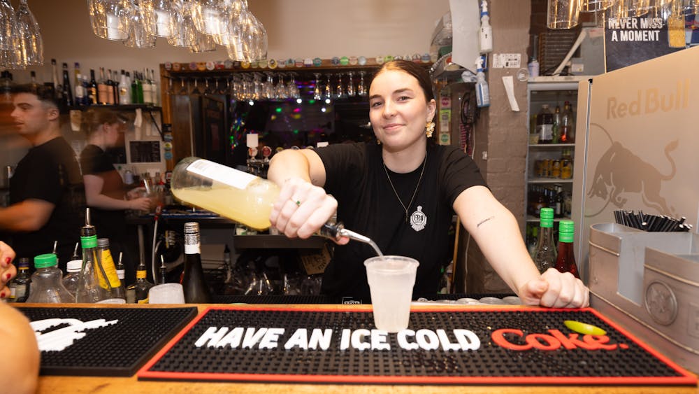 Bartender pouring a drink behind the bar at Freight Bar during a party event.