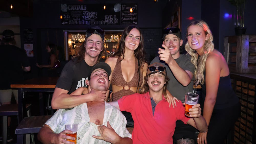 Group of friends posing with drinks inside Freight Bar.
