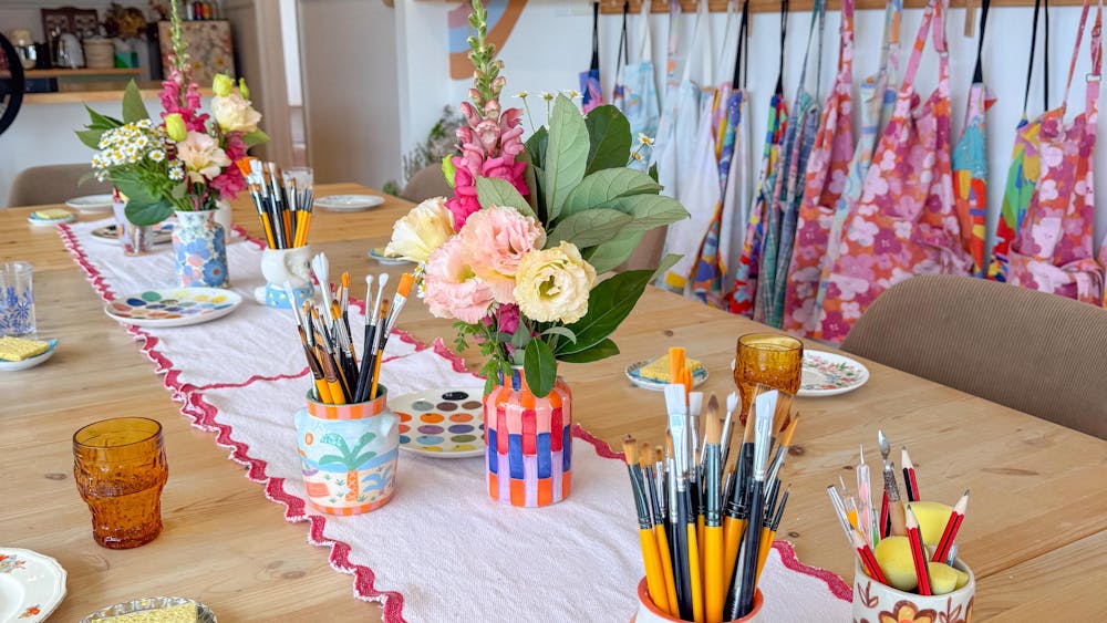 A close up of the workshop table showing brushes and materials for the workshop