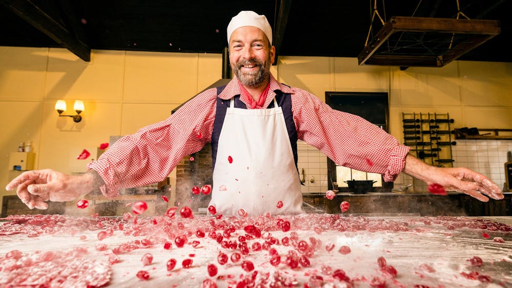 Confectioner smashing Raspberry Drops on bench