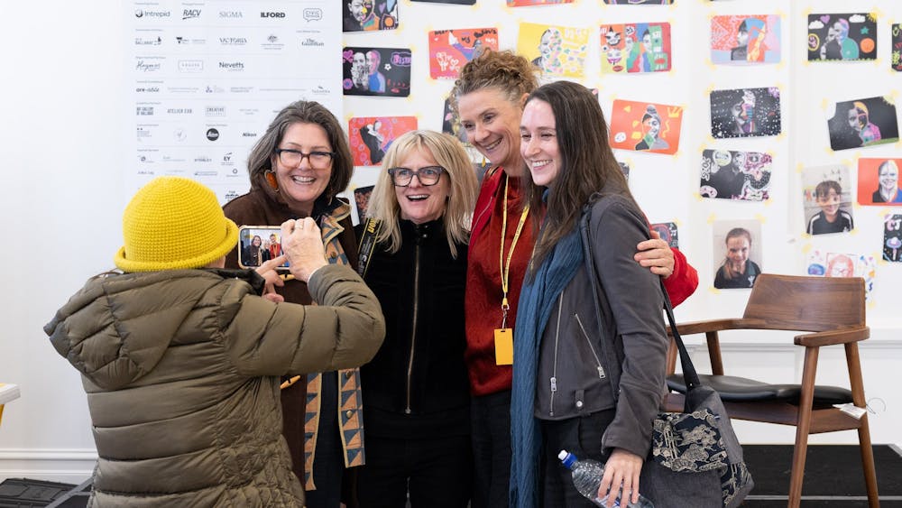 A person is taking a photograph of four women