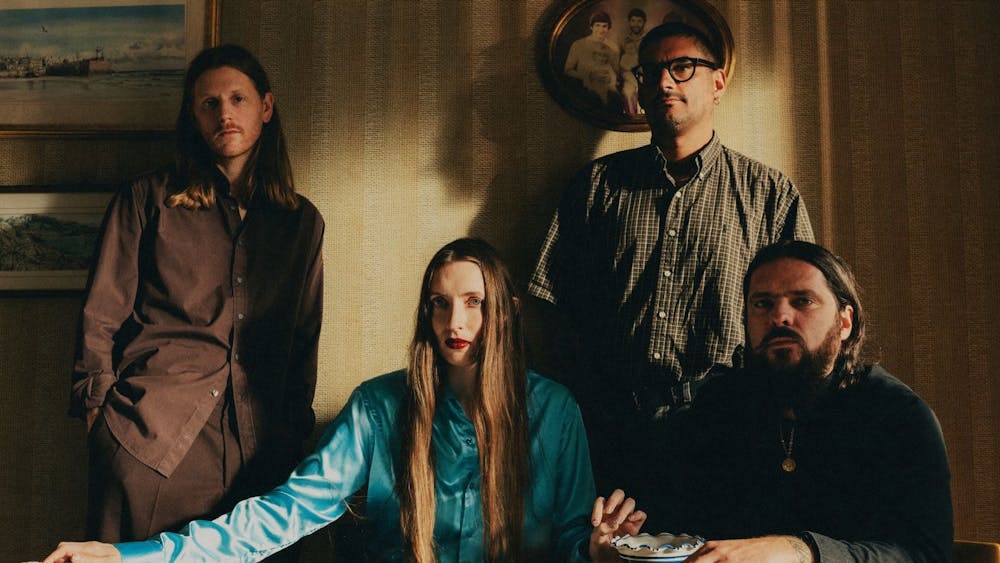 UK Art-Rockers, Dry Cleaning, sitting behind a table looking demure
