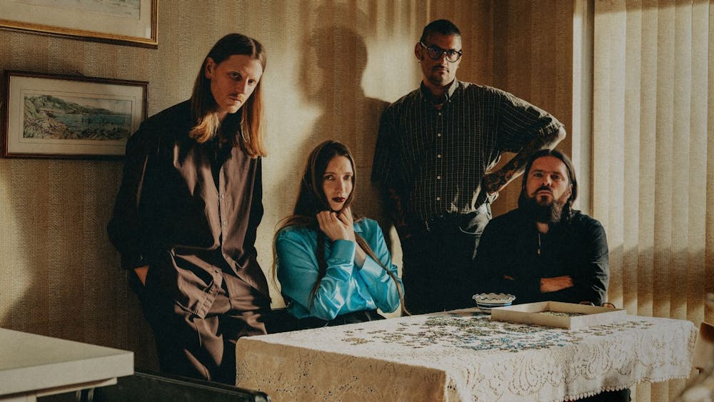 UK Art-Rockers, Dry Cleaning, sitting behind a table looking demure