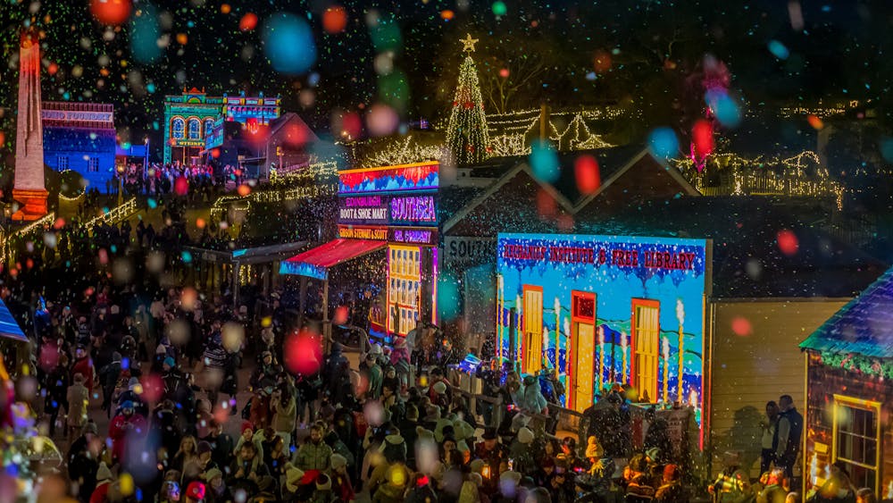 Night photo of Sovereign Hill buildings lit up with projections and crowds