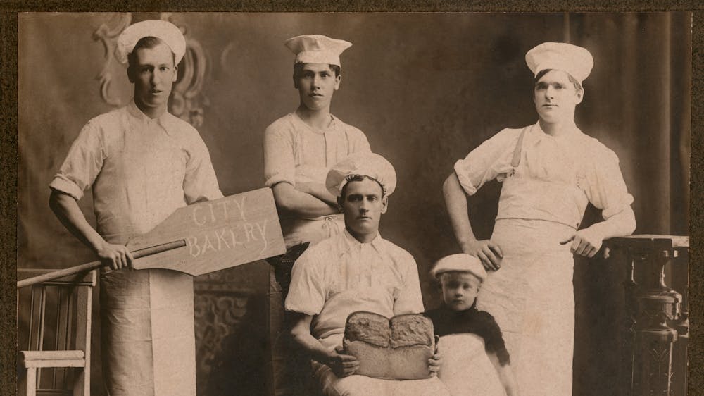 Five bakers posing for a black and white photograph (mid 20th century)