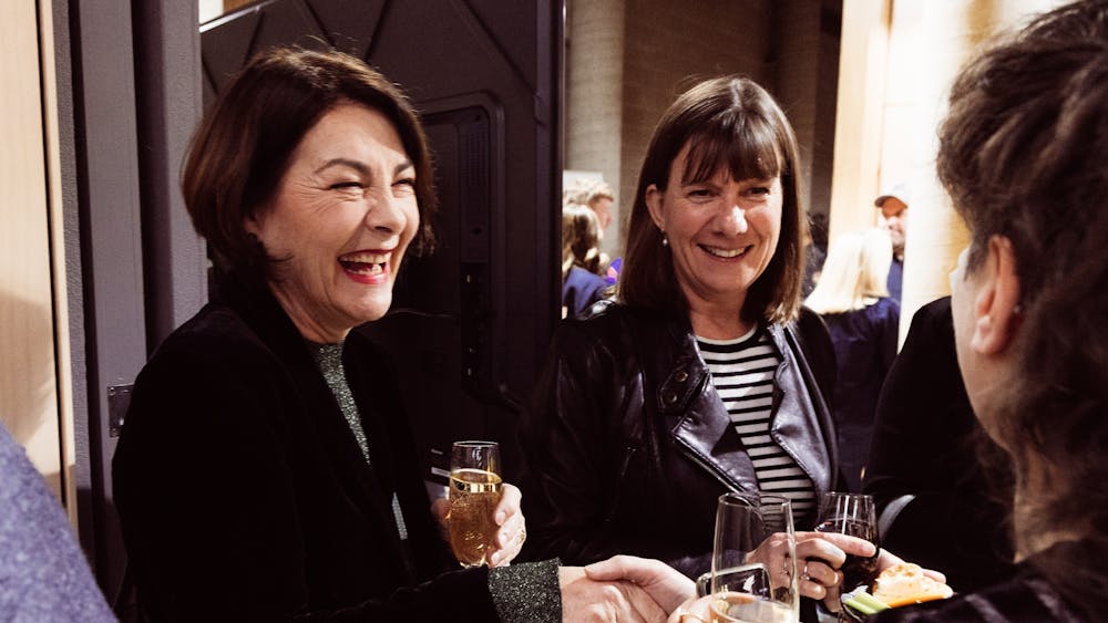 Group of people talking while holding  drinks