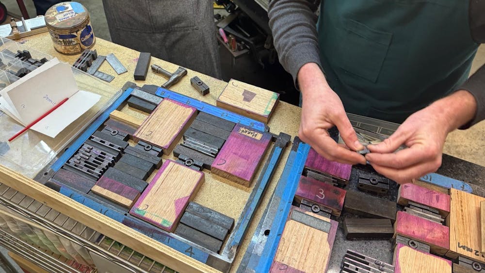 people's hands using letterpress and learning typesetting