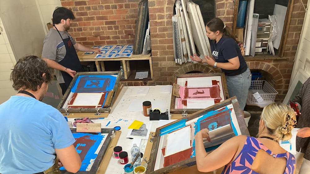 4 people screenprinting at a large table