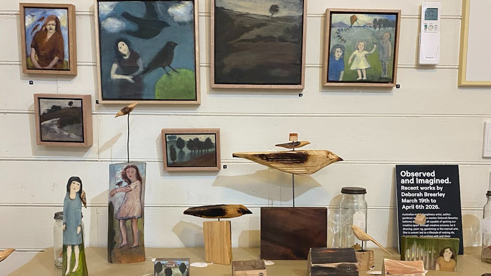 a collection of small paintings and sculptures on display