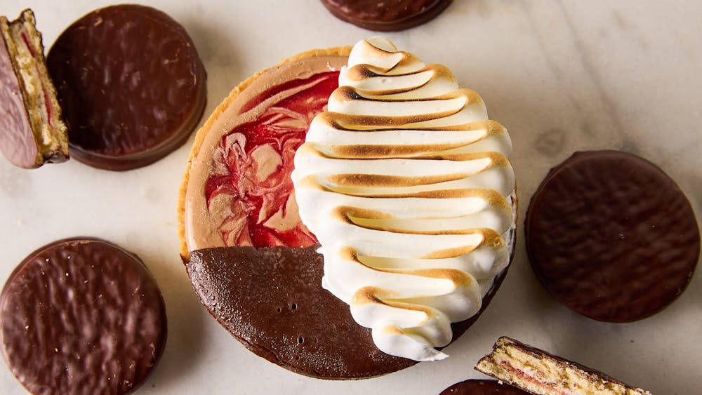 An overhead shot of a dessert pie with biscuits surrounding it