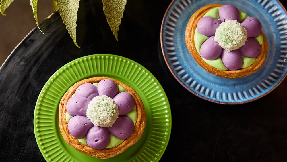 Two colourful dessert pies with pink and green icing