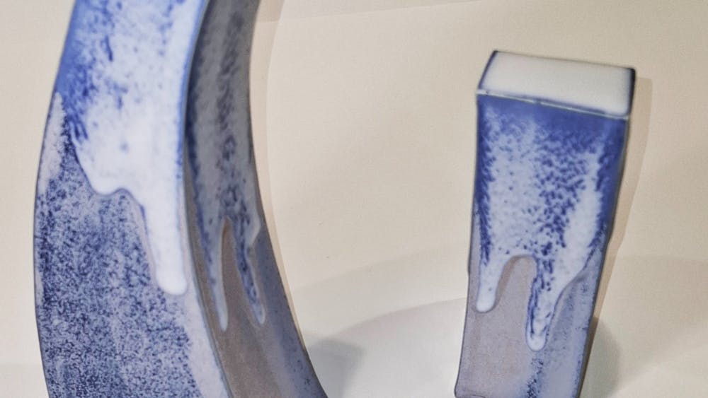Two elongated sculptural forms in blue and white glazing.