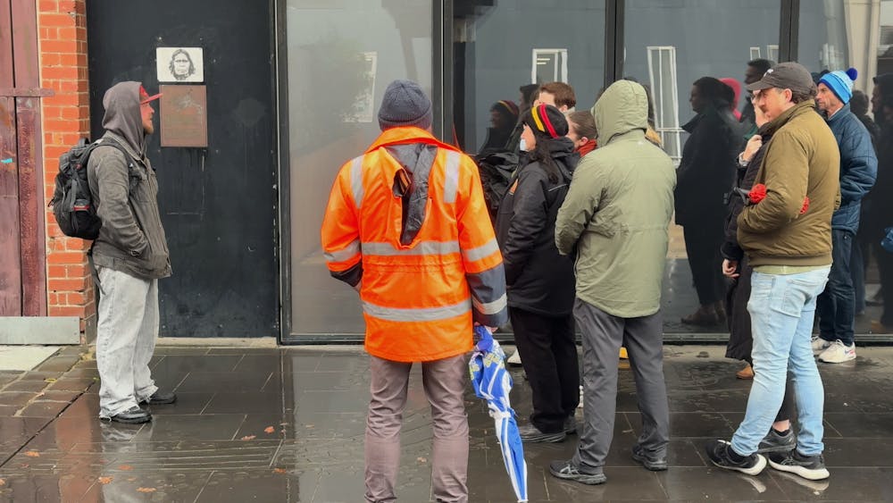 A group of people gathered around a public artwork, in an alley within the heart of Ballarat.