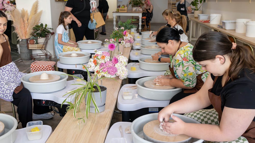 People participating in a wheel throwing workshop it our space.