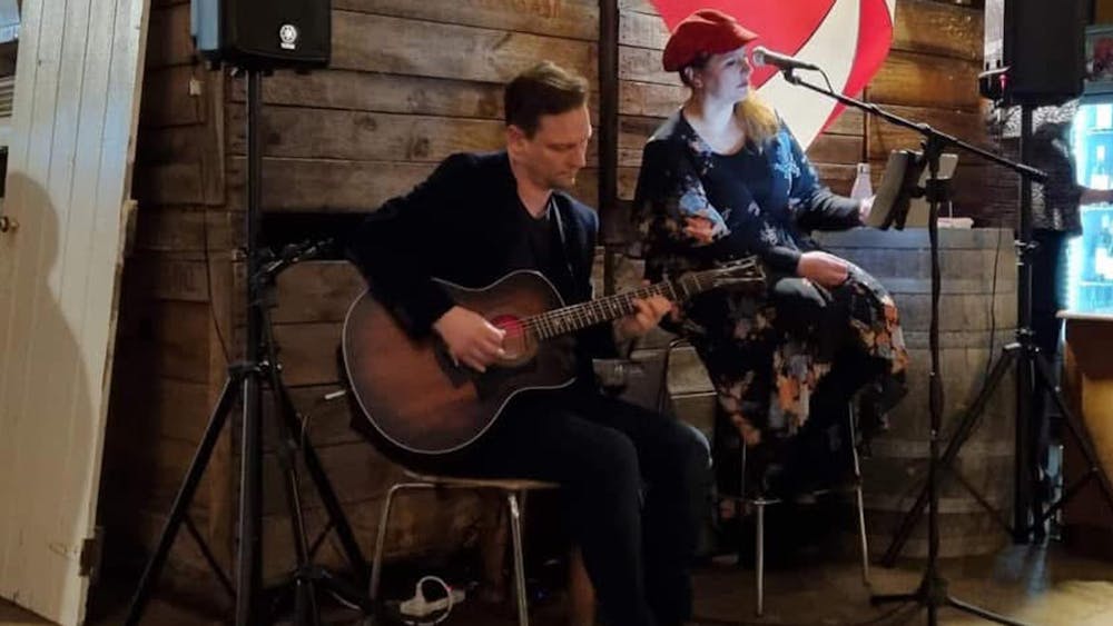 Lady and Man sitting. Mani is palying guitar