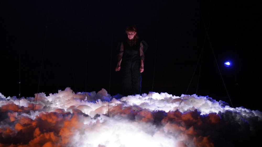 Zoë Barry playing the cello on a thunder cloud