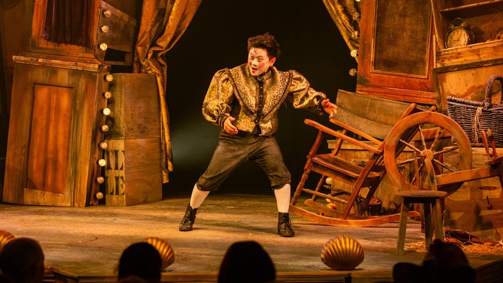 A man in a fancy outfit in front of an incredible stage set