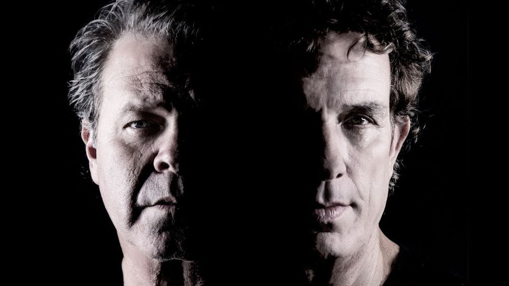Moody shot of the faces of Ian Moss and Troy Cassar-Daley half lit and half in total darkness