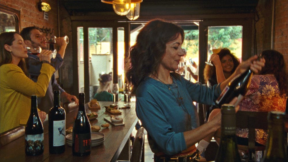 Woman looks at wine bottle in wine bar