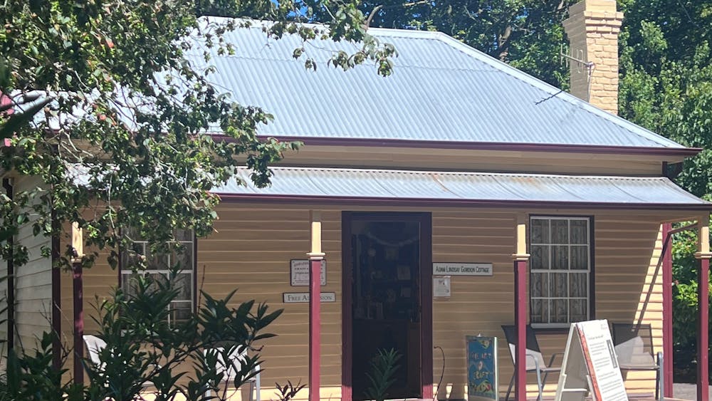 Exterior of the heritage wooden Adam Lindsay Gordon Craft Cottage in Ballarat Botanical Gardens with