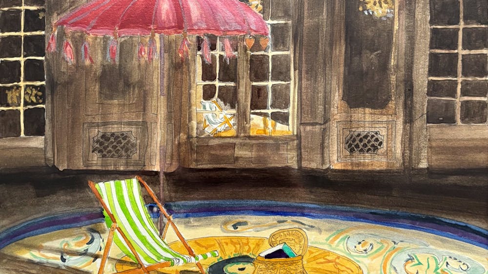 stiped deckchair on round yellow carpet with red beach tasseltedumbrella