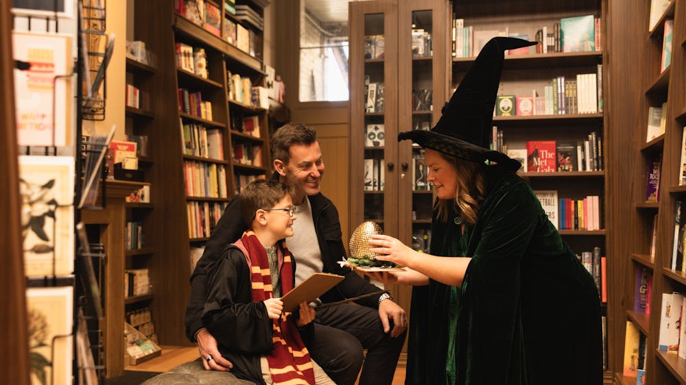 Father and son are entranced by Professor McGonagall showing them a dragon egg at Collins on Lydiard