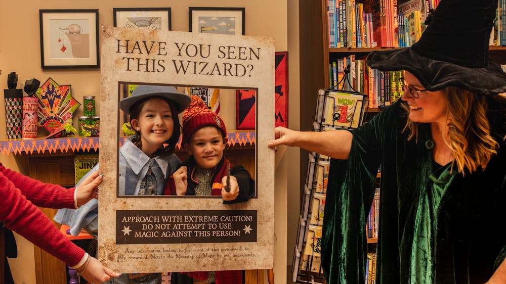 Two children dressed in Harry Potter costumes are posing in a photo frame at Collins on Lydiard