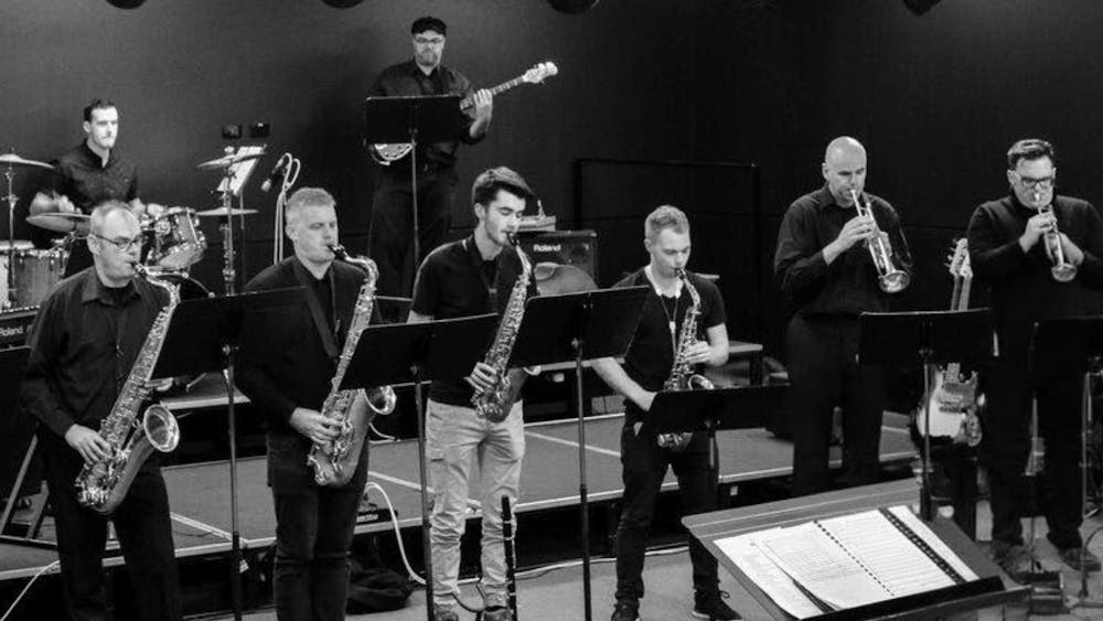 Members of Seb Big Band. People are playing trumpets, saxophones, bass, and drums.
