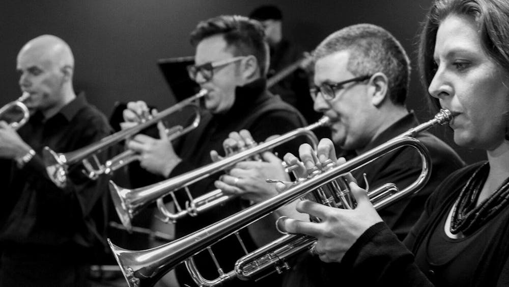 Four people playing trumpets.