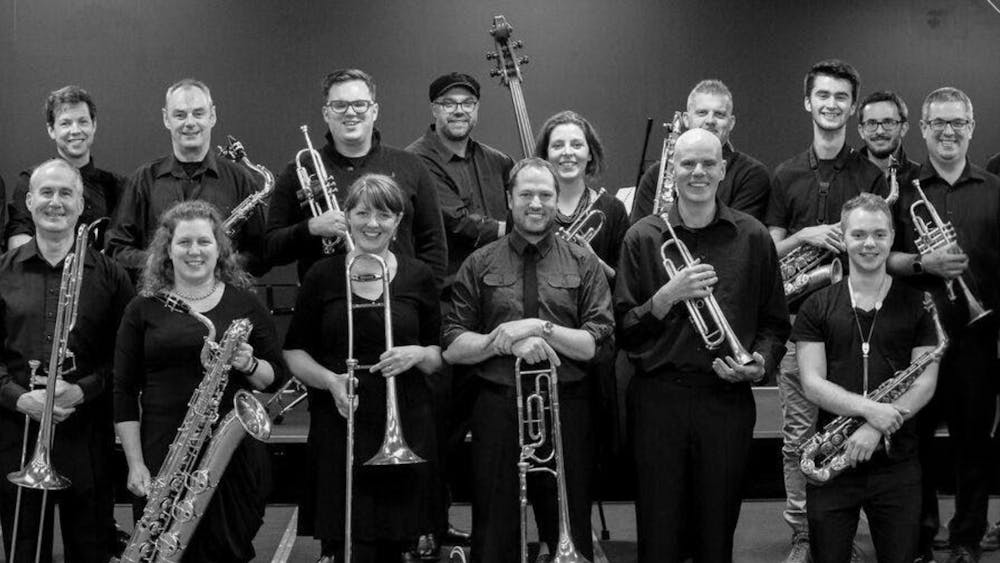 A black and white photo of a group of musicians holding instruments.
