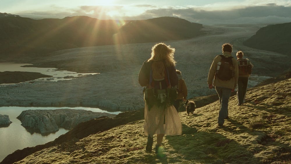 Family walking on a hillside into the rising sun