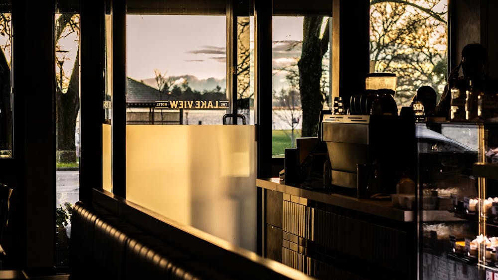 Interior café seating with views through the windows towards Lake Wendouree at sunset.