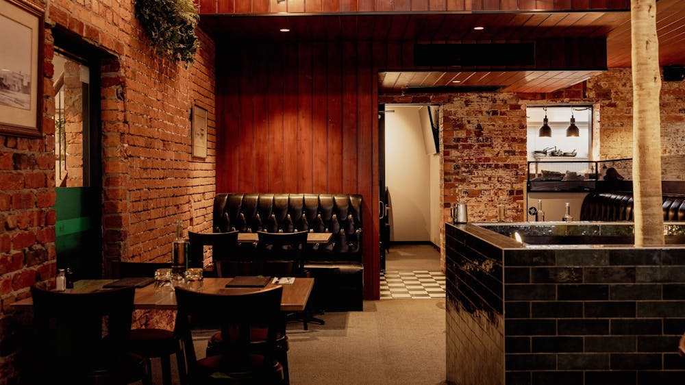 Dining area inside The North Star Hotel with timber finishes, exposed brick and comfortable booth