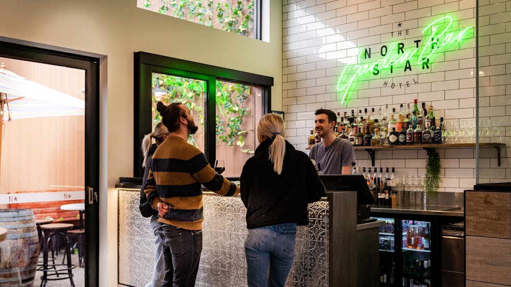 Guests ordering drinks at the bar inside The North Star Hotel.