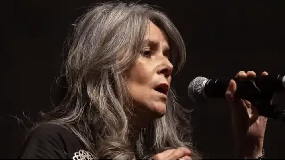Women with long hair standing singing into microphone