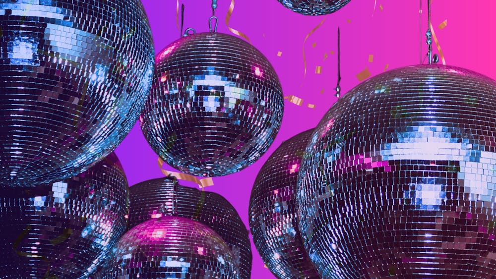 Pink and purple background with hanging mirror balls and gold confetti