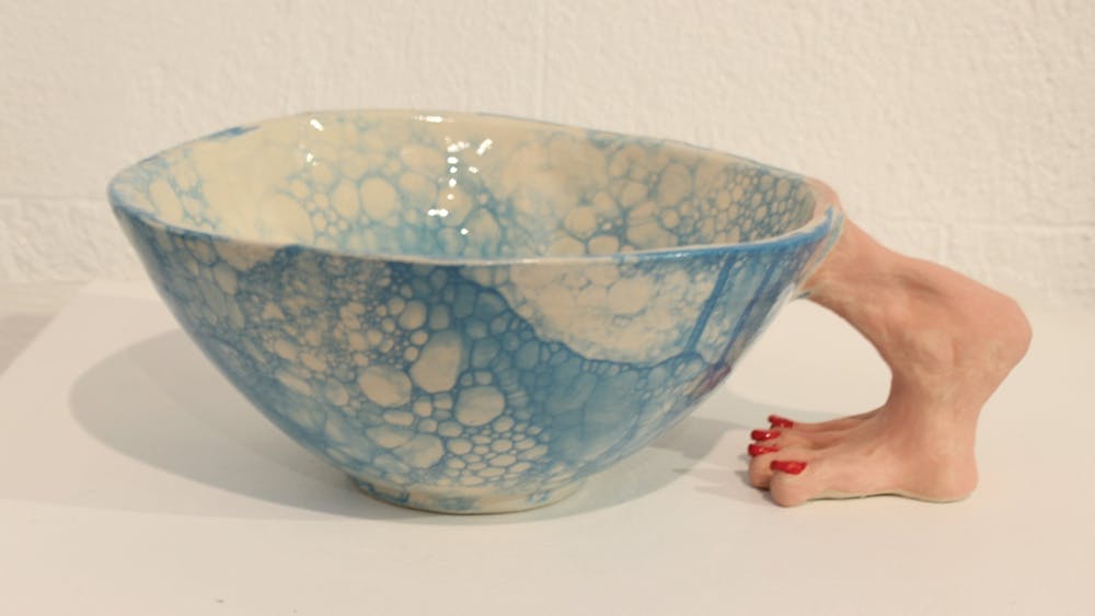 Pottery bowl in blue tones that features a pottery foot as the handle