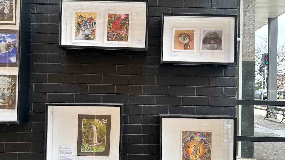 Outdoor gallery boxes on a wall displaying the collages of the current exhibition.