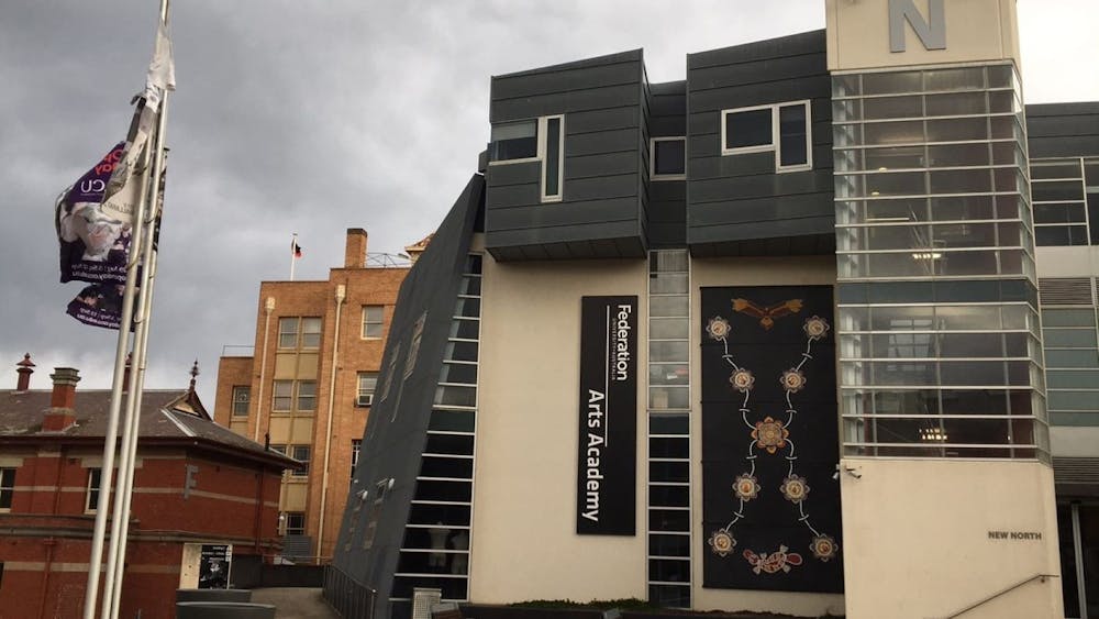 The mural is hanging on the side of a building, and is an indigenous artwork depicting Bunjil