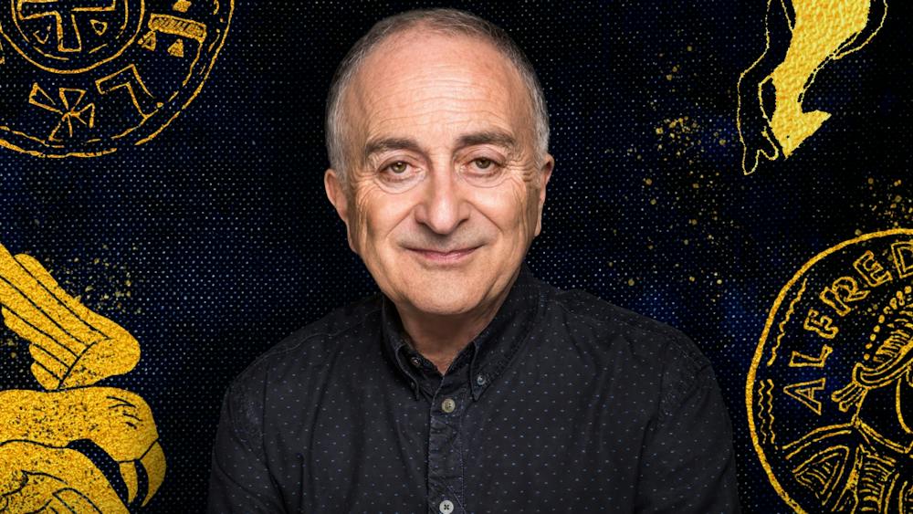 Sir Tony Robinson in a black shirt against a black backdrop with historical drawings in yellow