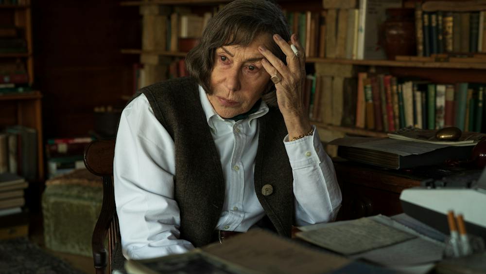 Woman sits at writing desk