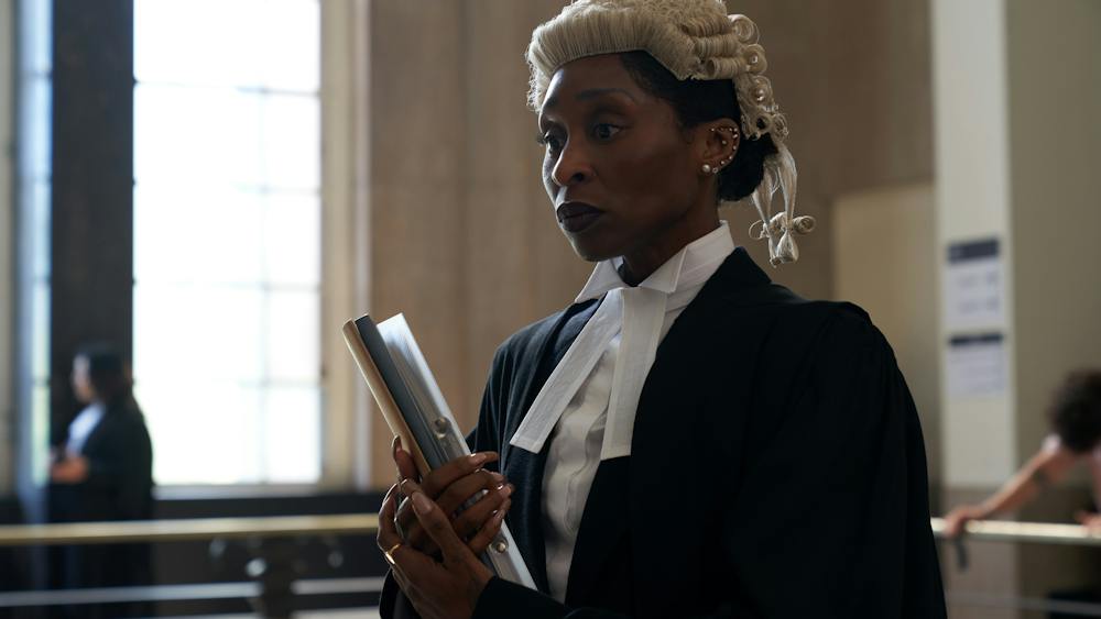 Woman in lawyer silks stands in courtroom