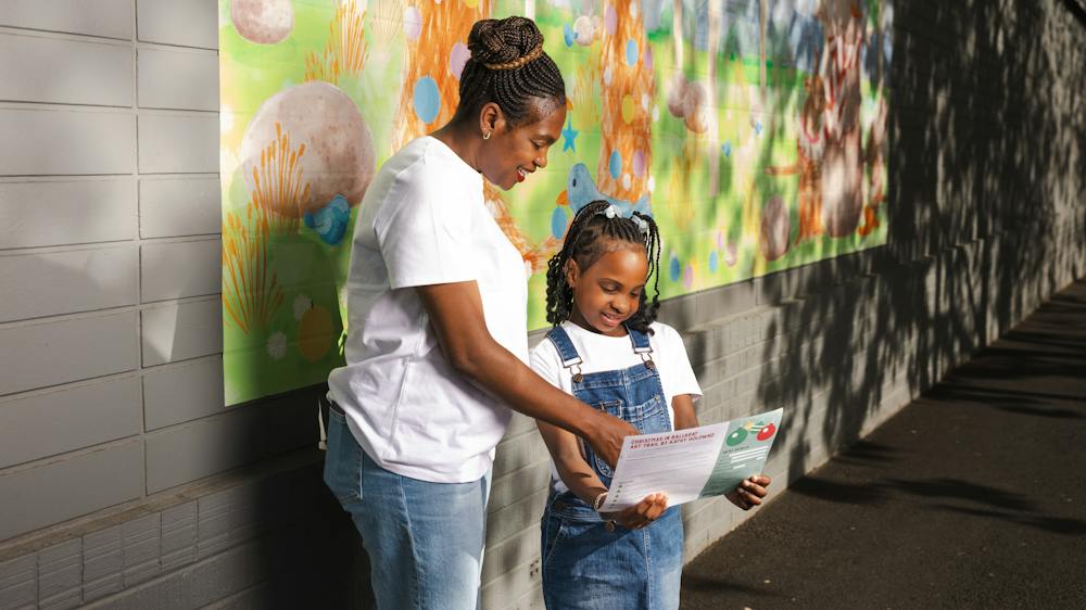 Adult & child reading map in front of artwork