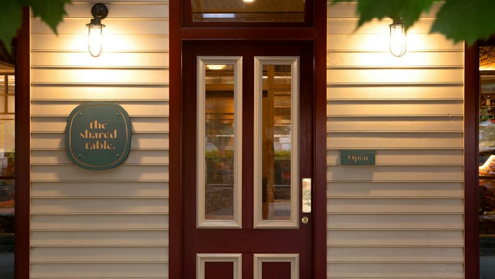 Front door of The Shared Table looking through grape vine leaves