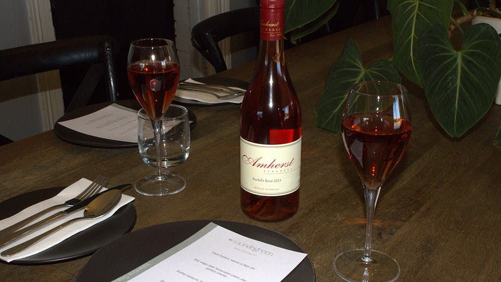 A table setting including two glasses and a bottle of local Rose Wine