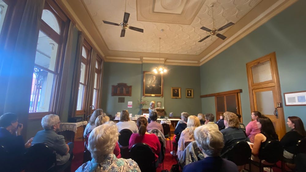 An interested crowd listening to an author speak about their work.