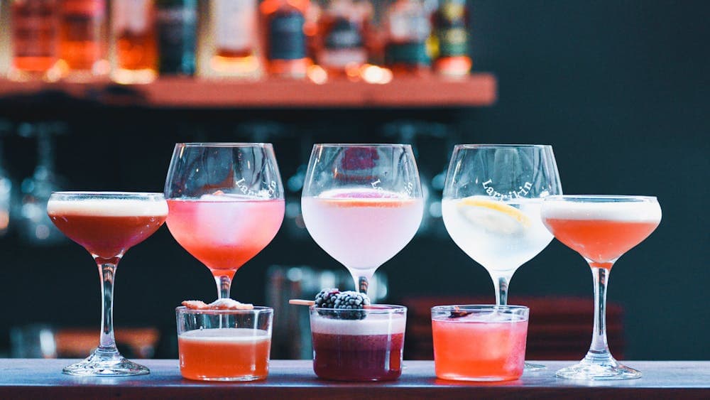 A line up of colourful cocktails in different sized glasses